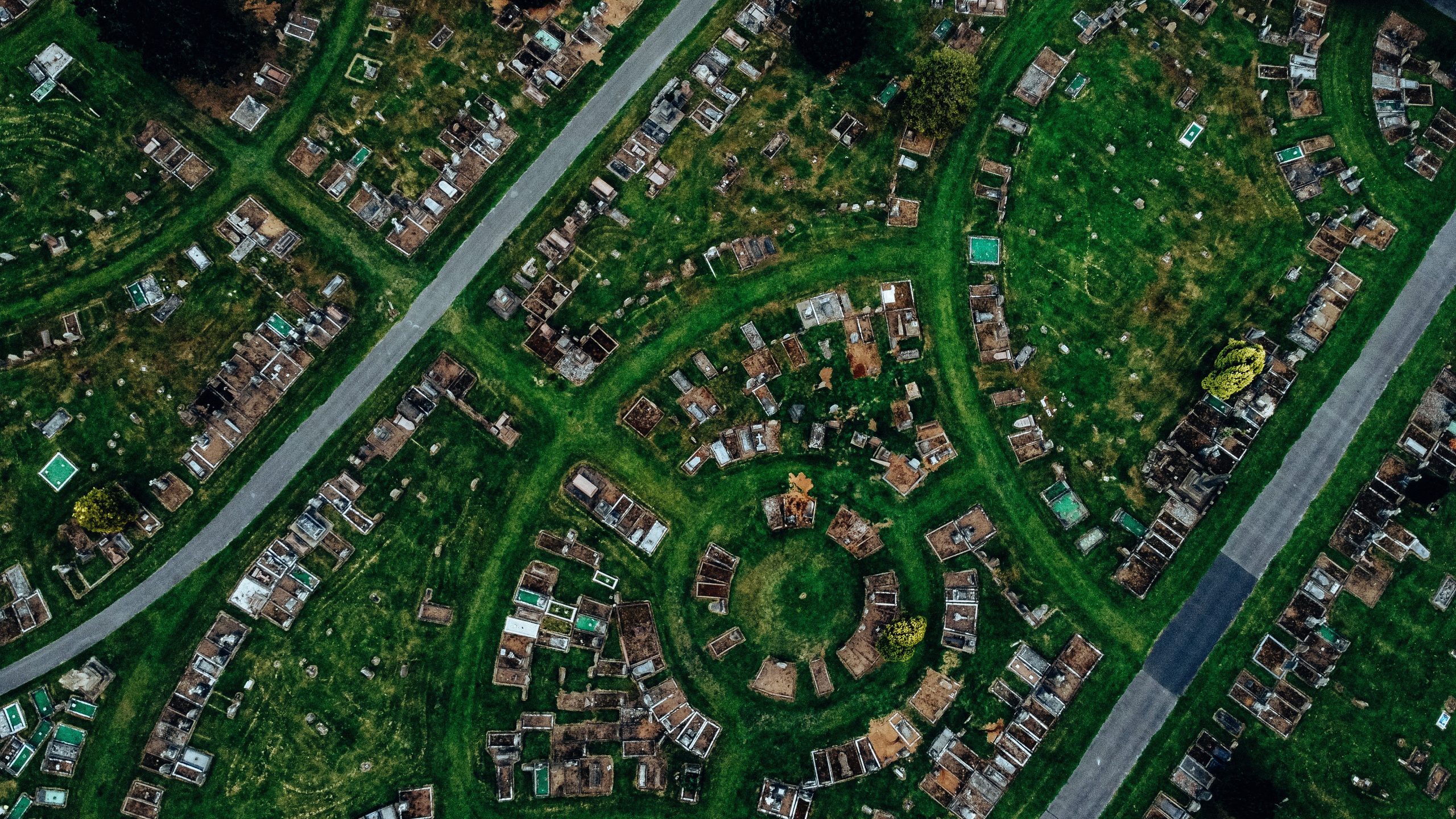 Aerial shot of a cemetery with circular gravestone arrangement from above.